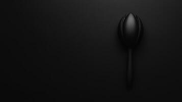 Elegant black spoon rests gracefully on a dark surface photo