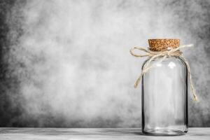 Glass jar with cork lid and twine on neutral background photo