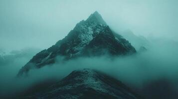 Majestic mountain peak enveloped in mysterious misty fog photo