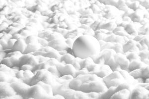 White sphere nestled in soft, fluffy snow blanket during winter photo