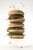 Deliciously stacked burgers floating in mid air with fresh toppings photo
