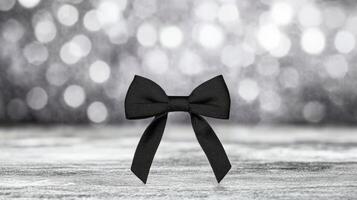 Elegant black bow against shimmering backdrop in soft light photo