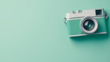 Vintage style camera resting on a teal background photo