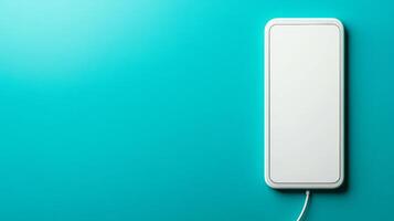Modern smartphone charging on a turquoise background photo