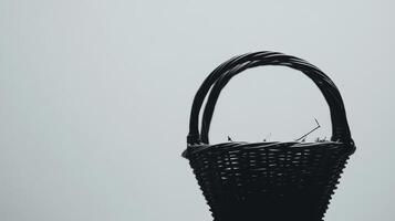 Wicker basket silhouette against a plain backdrop in soft light photo