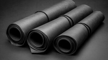 Rolls of black paper arranged together on a dark surface photo