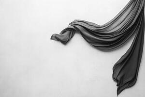 Flowing black fabric drapes against a light background photo