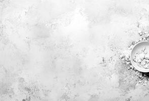 White flour scattered on a gray surface with a bowl photo