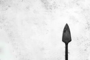Simple black garden spade on a textured background photo