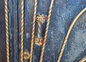 Close-up of a gilded iron gate handle with a twisted pattern. photo