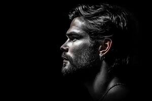 Striking studio portrait of a bearded man against a black background, highlighting his strong features and dramatic lighting photo