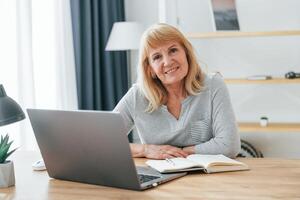 A woman is sitting at a desk with a laptop photo