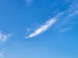 Feathery white fluffy clouds a blue sky background photo