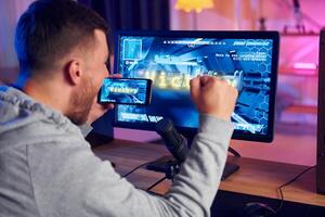 A man is playing a game on a computer monitor photo