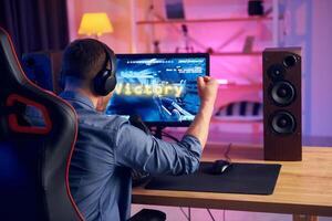 A man is playing a game on a computer photo