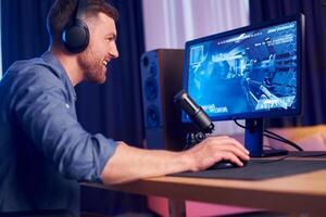 A man wearing headphones is playing a game on a computer photo