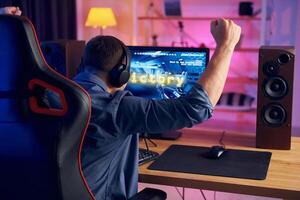 A man sitting at a desk with his arms up photo