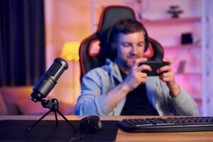 A man sitting at a desk with a computer and a microphone photo