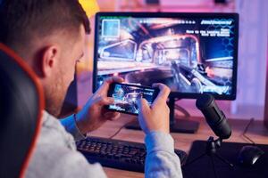 A man is playing a game on his phone photo