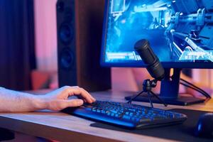 A man is using a keyboard and mouse to play games photo