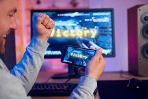 A man is playing a game on his phone photo