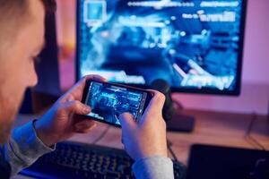 A man is playing a game on his phone photo