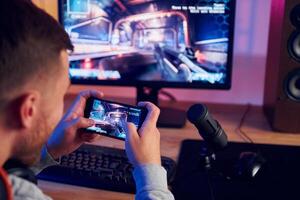 A man is playing a game on his phone photo