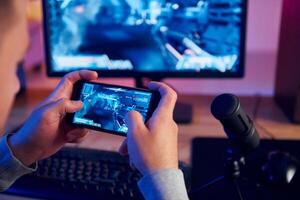 A man is playing a game on his phone photo