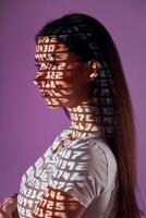 A woman with her arms crossed and her shadow projected on her face photo
