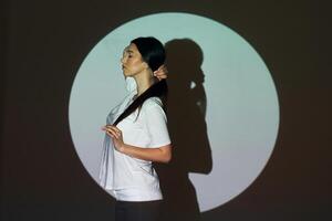 A woman standing in front of a projection of a circle photo