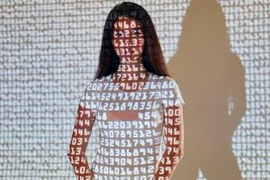 A woman standing in front of a wall with numbers on it. photo