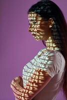 A woman with her arms crossed and her shadow projected on a wall photo