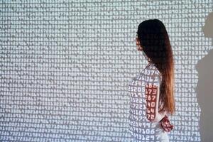 A woman standing in front of a wall with numbers on it photo