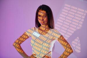 A woman standing in front of a wall with text on it photo