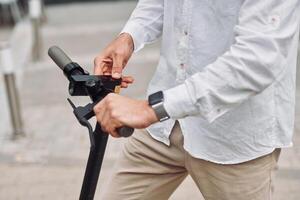 A man is holding onto the handle of a scooter photo