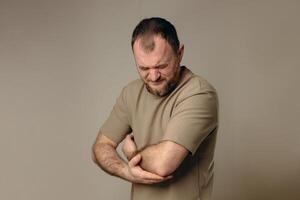 A man experiences problems in the elbow after intense physical exercise, long training or professional activities. performing a warm-up and recovery after physical exercise. photo