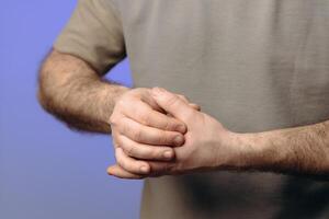 the man suffers from chronic gout - the deposition of uric acid crystals in the joints, causing sharp, severe pain, most often in the thumb. pain in the joints of the fingers. hands close-up photo