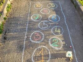In the courtyard on the asphalt there is a drawing of classics in chalk figures photo
