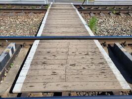 Boardwalk between the rails. Crossing railway tracks. photo