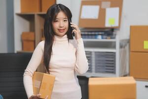 A woman holding a box and talking on the phone photo