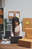 A woman sitting at a desk with boxes on the floor photo