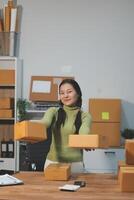 A woman is sitting at a desk with boxes photo