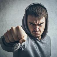 Angry man in hoodie pointing at camera photo
