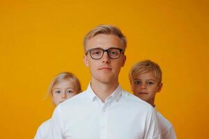 Group portrait of a young man and children with a bright yellow background in a studio setting photo