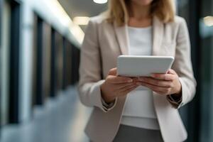 Business professional uses tablet while walking in modern office hallway during work hours photo