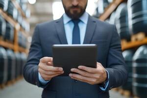 Business professional inspects inventory with tablet in warehouse filled with storage tanks photo