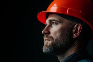 Construction worker in hard hat looking thoughtfully during a safety briefing at a job site in the evening photo