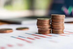 Stacked coins on financial reports indicate savings trends and investment analysis for future planning in a workspace setting photo