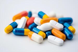 Variety of colorful capsules and tablets scattered on a plain surface for pharmaceutical display photo