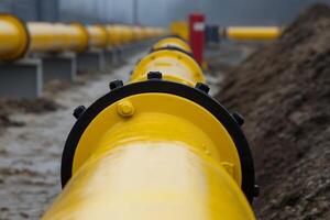 Industrial pipeline system under overcast weather conditions near a construction site with earthworks in progress photo
